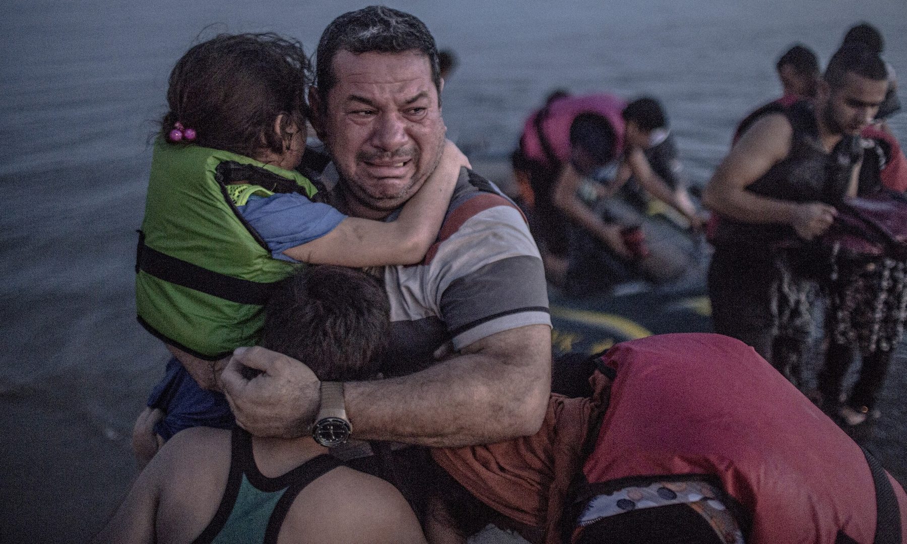 A Syrian refugee holding his son and daughter